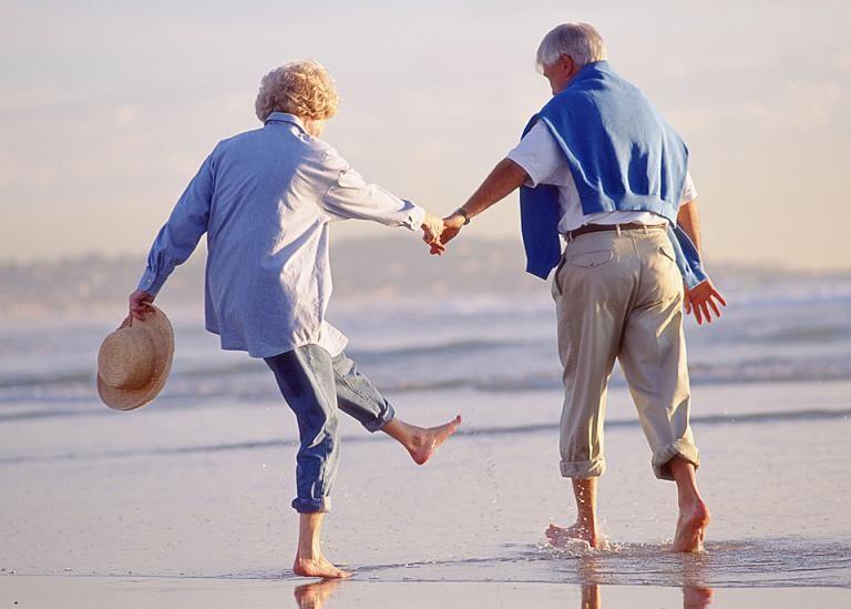 Couple in later life paddling in the ocean